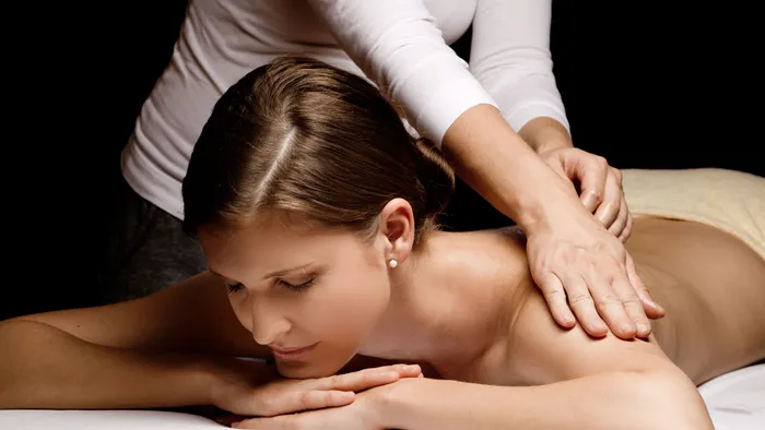 Entspannte Frau erhält eine professionelle Rückenmassage im Spa